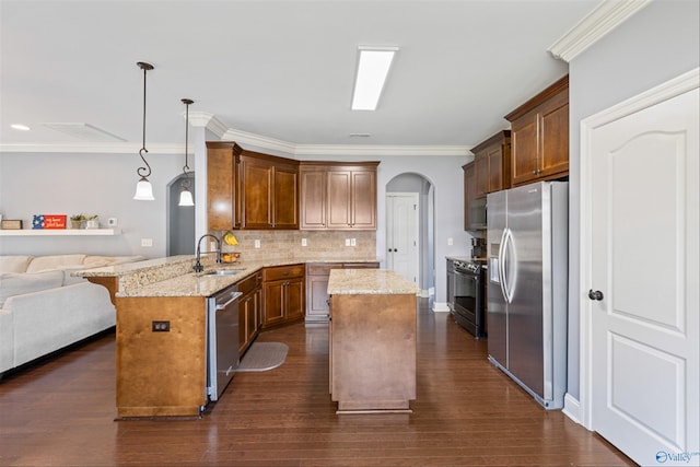 kitchen with sink, stainless steel appliances, a kitchen breakfast bar, decorative light fixtures, and kitchen peninsula