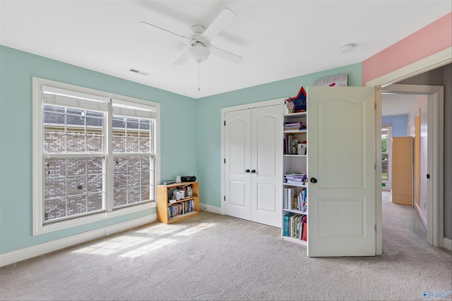 interior space with light carpet and ceiling fan