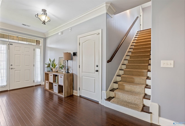 foyer entrance featuring crown molding and dark wood-type flooring