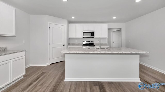 kitchen featuring light hardwood / wood-style flooring, stainless steel appliances, white cabinetry, and a kitchen island with sink