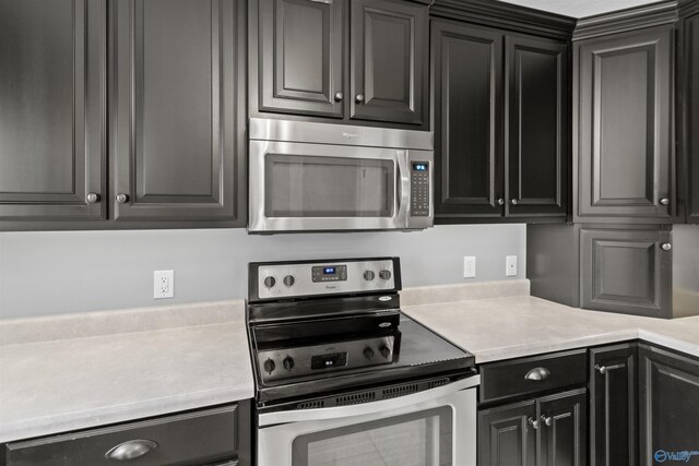18226 Whitetail Ln, Athens, AL 35613 - kitchen featuring appliances with stainless steel finishes, light countertops, and dark cabinets