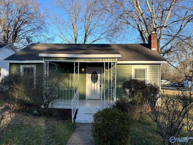 bungalow featuring a porch and a chimney