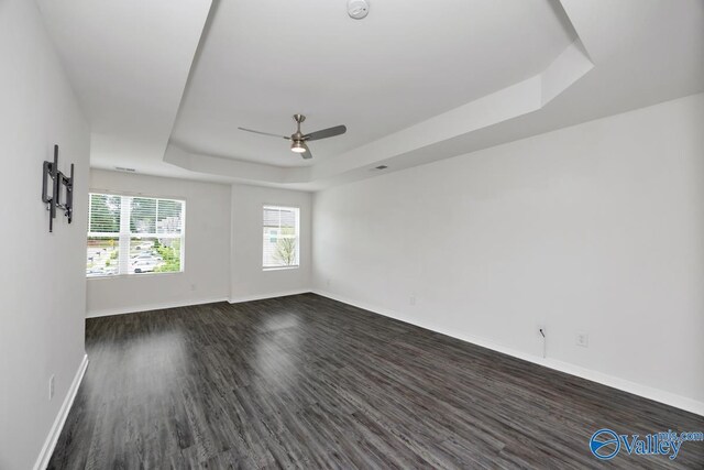 6032 Barringer Ct, Huntsville, AL 35806 - empty room with a ceiling fan, baseboards, a raised ceiling, and dark wood finished floors