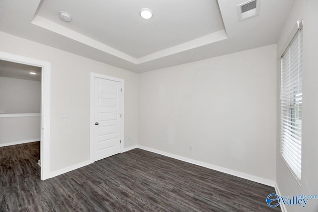 6032 Barringer Ct, Huntsville, AL 35806 - unfurnished bedroom with dark wood-type flooring, visible vents, and a raised ceiling