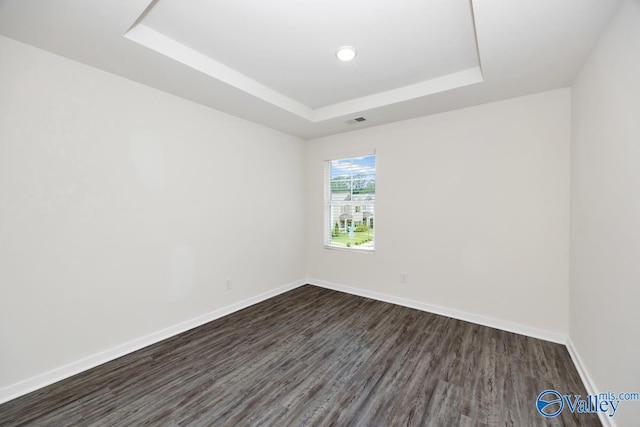 6032 Barringer Ct, Huntsville, AL 35806 - unfurnished room with a tray ceiling, baseboards, visible vents, and dark wood-style floors