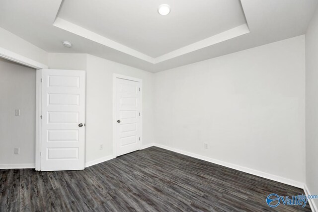 6032 Barringer Ct, Huntsville, AL 35806 - unfurnished bedroom featuring a raised ceiling, baseboards, and dark wood finished floors