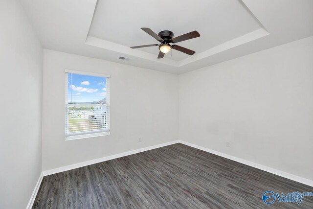 6032 Barringer Ct, Huntsville, AL 35806 - empty room with baseboards, dark wood finished floors, visible vents, a tray ceiling, and ceiling fan