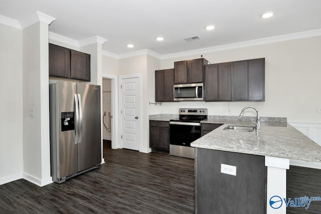 6032 Barringer Ct, Huntsville, AL 35806 - kitchen with dark brown cabinetry, a peninsula, visible vents, appliances with stainless steel finishes, and a sink