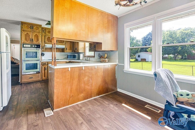 3392 Williams St, Hokes Bluff, AL 35903 - kitchen featuring stainless steel microwave, double oven, brown cabinetry, and under cabinet range hood
