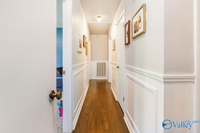 3392 Williams St, Hokes Bluff, AL 35903 - hallway featuring attic access, a wainscoted wall, dark wood finished floors, and a decorative wall