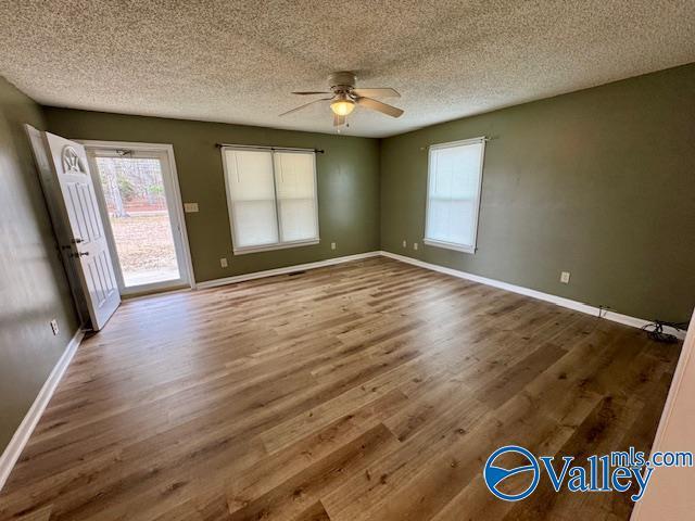 unfurnished room with ceiling fan, dark hardwood / wood-style flooring, and a textured ceiling