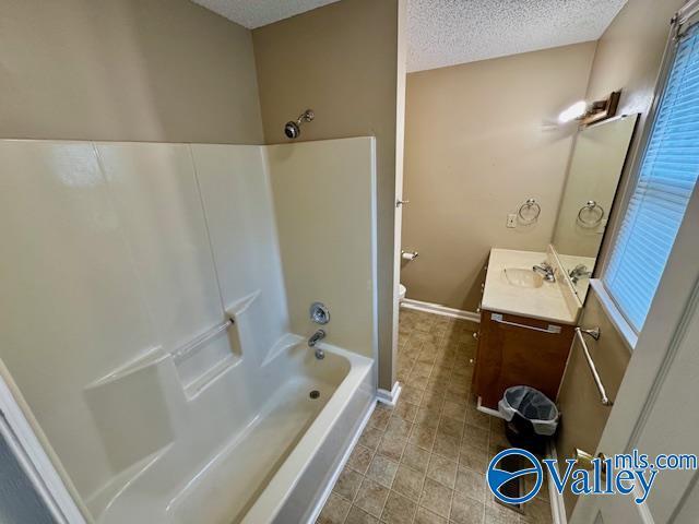 full bathroom featuring shower / bath combination, vanity, a textured ceiling, and toilet