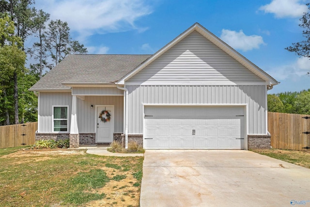 1207 Sommers Ridge Dr, Athens, AL 35611 - view of front of home with fence, driveway, a shingled roof, and a garage