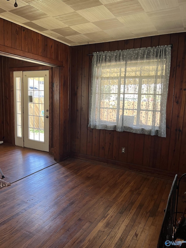 interior space with dark wood-type flooring and wood walls