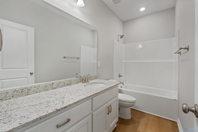 full bath with visible vents, tub / shower combination, toilet, wood finished floors, and vanity