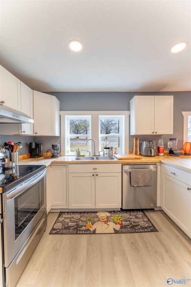 kitchen with stainless steel appliances, sink, and white cabinets