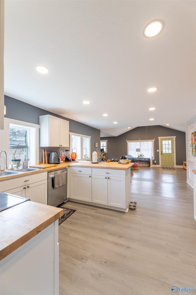 kitchen featuring sink, dishwasher, white cabinetry, wood counters, and kitchen peninsula