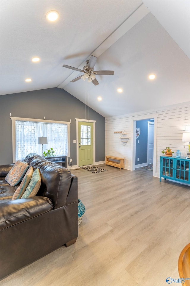 living room with vaulted ceiling, ceiling fan, and light wood-type flooring
