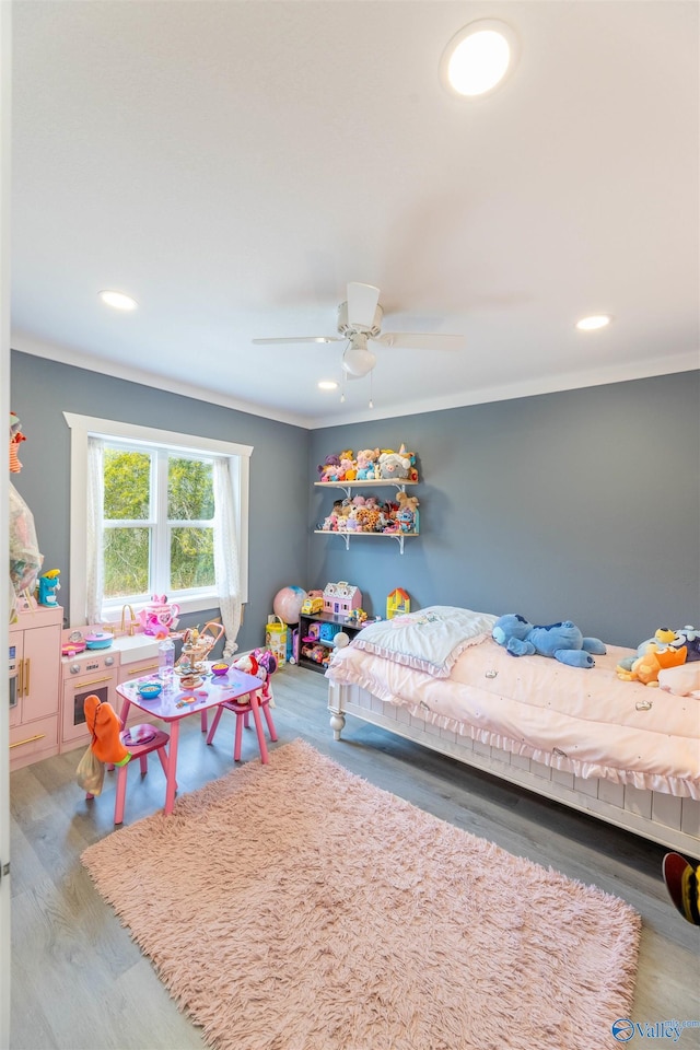 bedroom with wood-type flooring, ornamental molding, and ceiling fan
