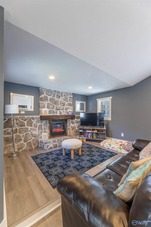 living room featuring hardwood / wood-style flooring, a fireplace, and a textured ceiling