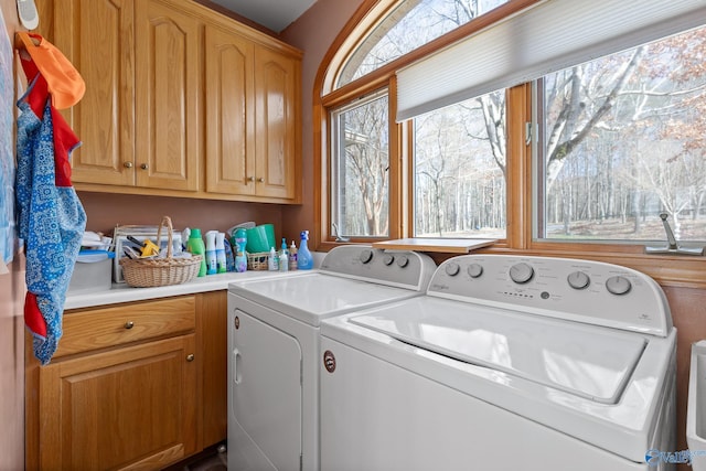 washroom with cabinets and washer and clothes dryer