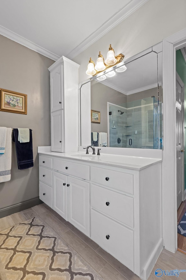 bathroom featuring vanity, ornamental molding, a shower with door, and wood-type flooring