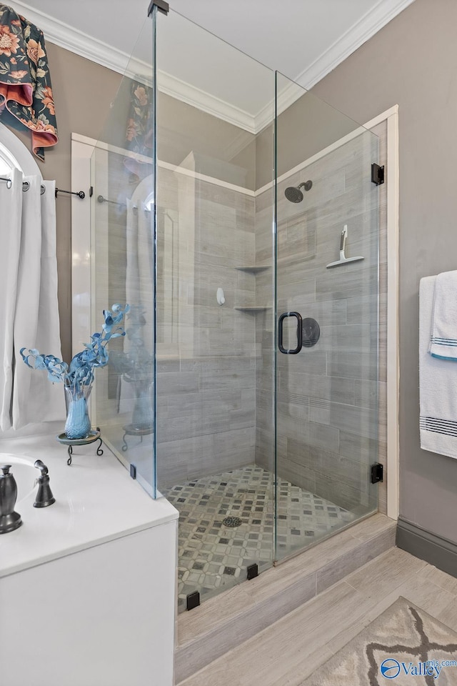 bathroom featuring a shower with door and ornamental molding