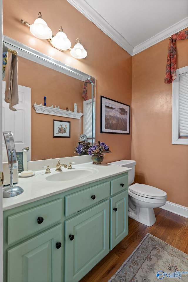 bathroom featuring ornamental molding, wood-type flooring, vanity, and toilet