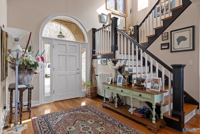 entrance foyer featuring hardwood / wood-style flooring and a towering ceiling