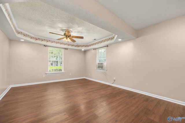 spare room featuring ceiling fan, a tray ceiling, wood-type flooring, and a textured ceiling