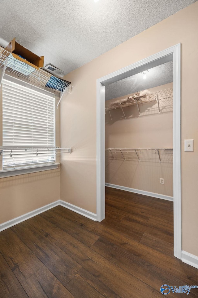 walk in closet with dark hardwood / wood-style flooring