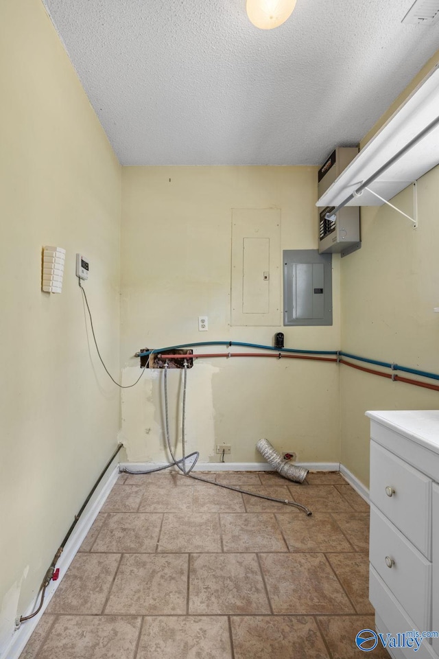 laundry area with electric panel and a textured ceiling