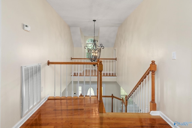 stairs featuring a notable chandelier