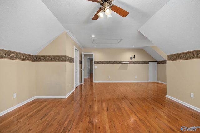 additional living space with hardwood / wood-style flooring, a textured ceiling, and ceiling fan