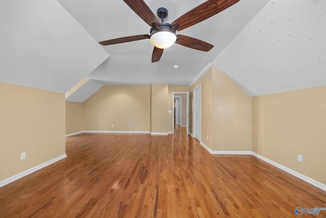 bonus room featuring lofted ceiling, light hardwood / wood-style flooring, and ceiling fan