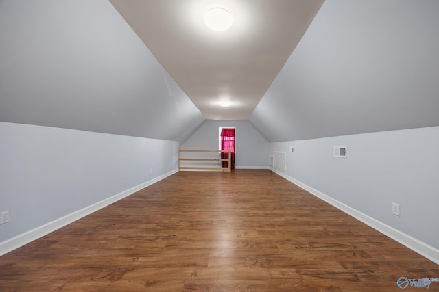 additional living space featuring lofted ceiling and dark hardwood / wood-style flooring