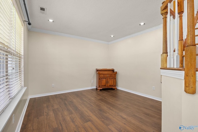 spare room with dark hardwood / wood-style flooring, ornamental molding, and a textured ceiling