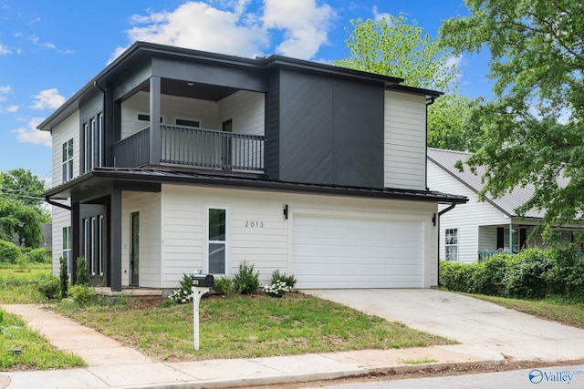 view of front of home featuring a balcony, an attached garage, and concrete driveway