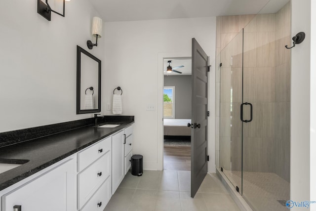 full bath with connected bathroom, a stall shower, tile patterned flooring, double vanity, and a ceiling fan