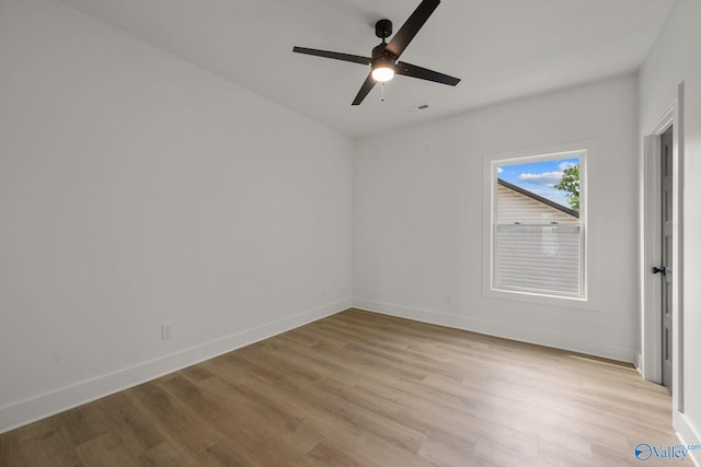 unfurnished room with a ceiling fan, light wood-style floors, and baseboards