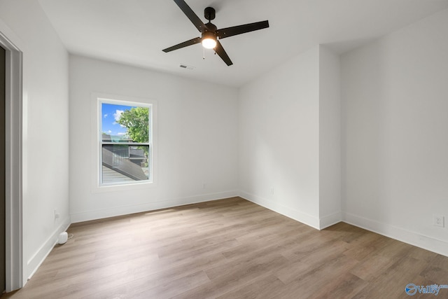 empty room with light wood-style flooring, ceiling fan, and baseboards