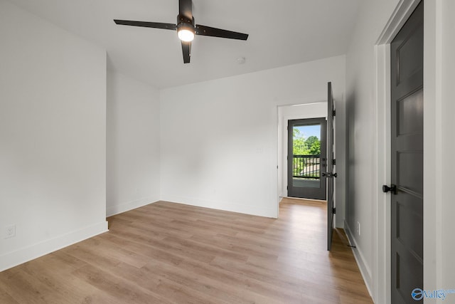 spare room with light wood-style flooring, a ceiling fan, and baseboards