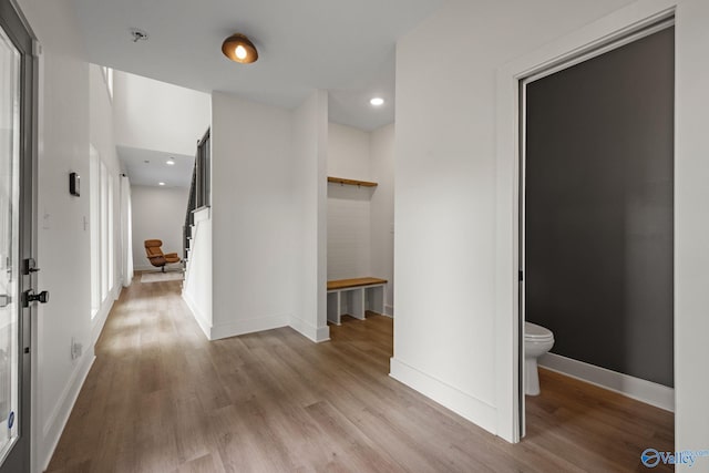 corridor featuring wood finished floors, baseboards, and recessed lighting