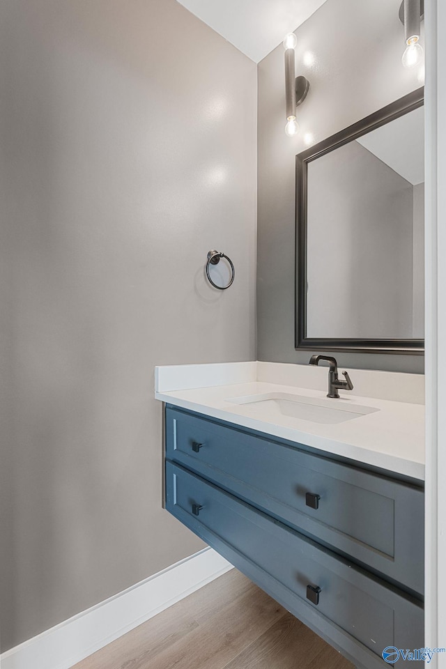 bathroom featuring wood finished floors, vanity, and baseboards