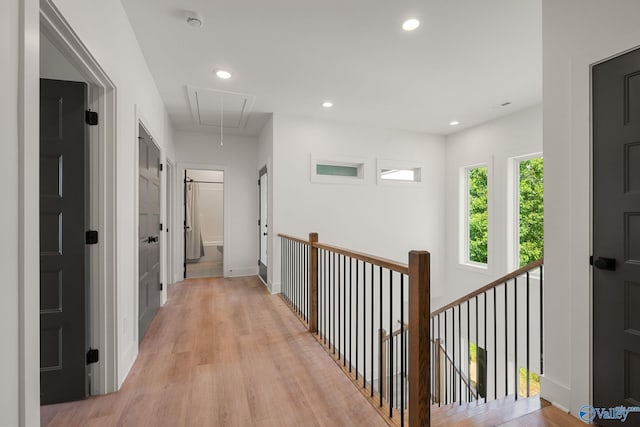 hall with attic access, light wood-style flooring, an upstairs landing, and recessed lighting