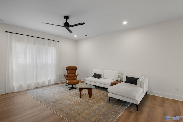 living area with wood finished floors, ceiling fan, baseboards, and recessed lighting