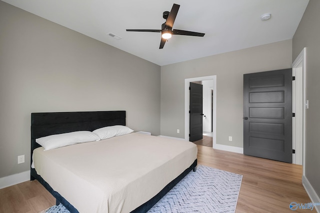 bedroom featuring light wood-type flooring, baseboards, and a ceiling fan