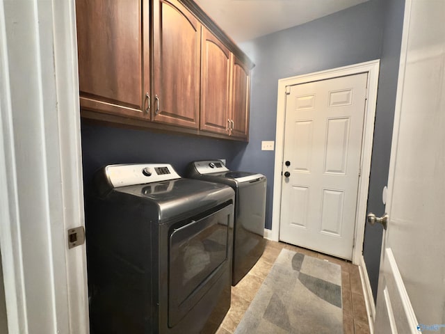 washroom featuring light tile patterned flooring, separate washer and dryer, and cabinet space