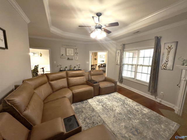 living room featuring baseboards, a raised ceiling, a ceiling fan, and crown molding