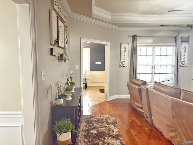 hallway featuring crown molding, a wainscoted wall, and wood finished floors